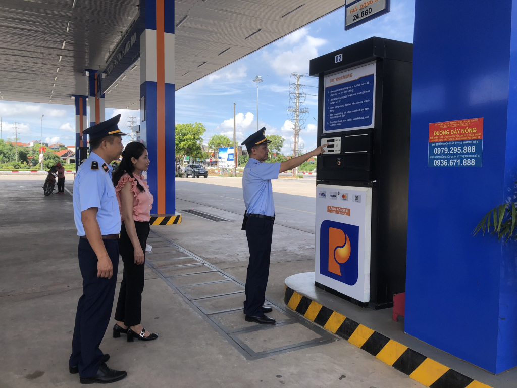 Lực lượng quản lý thị trường kiểm tra việc niêm yết giá, bán hàng tại cửa hàng xăng dầu 100 Petrolimex, TX Quảng Yên.