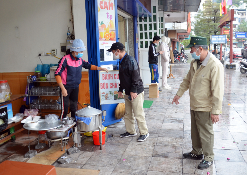 Ông Mai Văn Thư (áo đen), Bí thư chi bộ, Trưởng khu phố 5 (phường Bạch Đằng, TP Hạ Long) tuyên truyền, nhắc nhở các hộ kinh doanh không lấn chiếm vỉa hè, xây dựng khu phố văn hóa, an toàn.