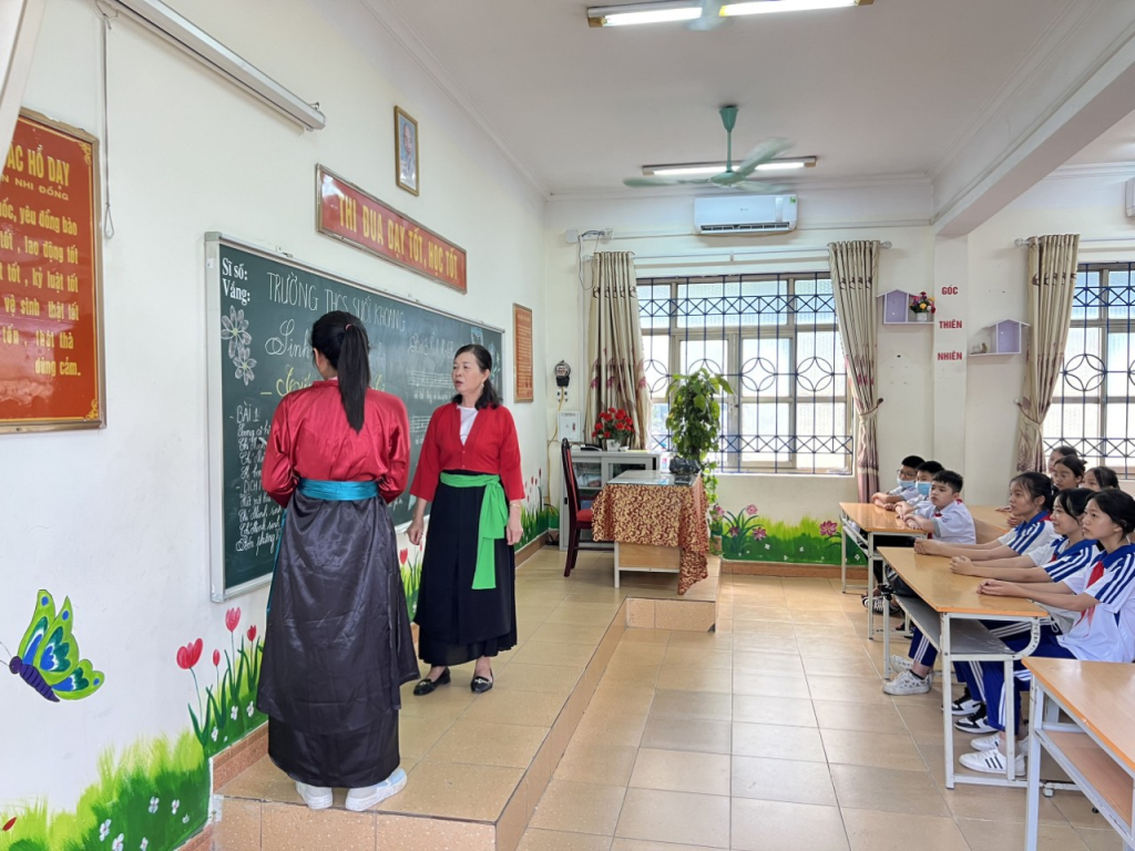 Bà Lê (bên phải) phối hợp dạy hát Soọng cô và tiếng Sán Dìu cho học sinh trong Chương trình ngoại khóa của Trường THCS Quang Hanh (TP Cẩm Phả)