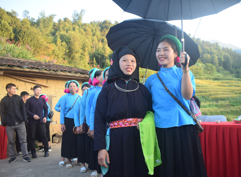 Cô dâu Sán Chỉ ở xã Lục Hồn, huyện Bình Liêu đội khăn và thắt lưng thêu hoa, đi cùng đoàn phù dâu mặc váy áo đặc trưng của phụ nữ Sán Chỉ