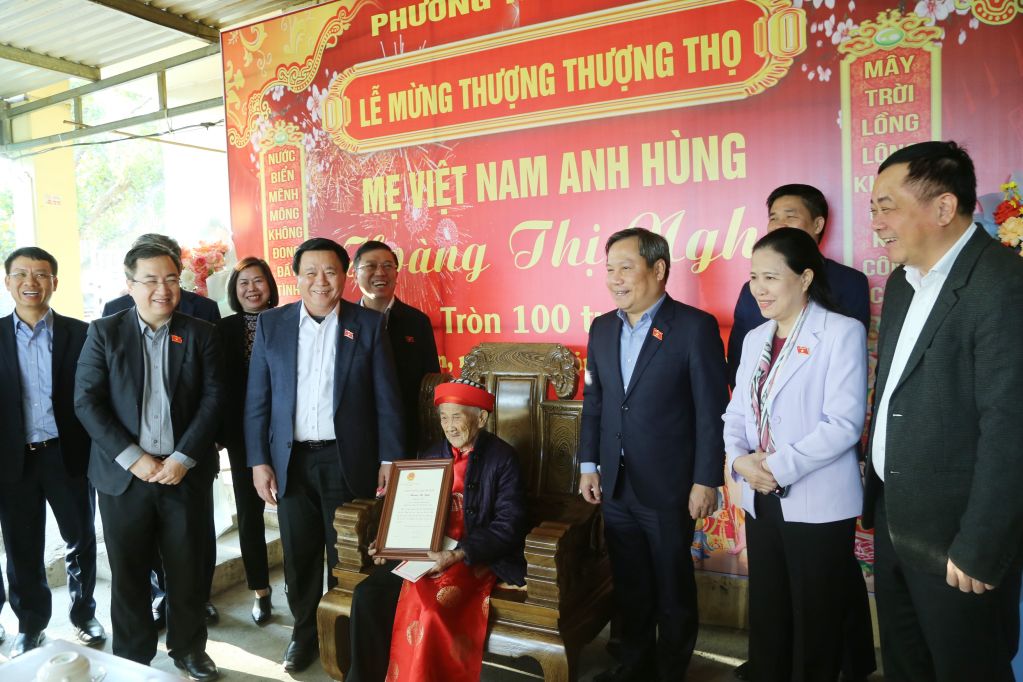 Đồng chí Nguyễn Xuân Thắng, Ủy viên Bộ Chính trị, Giám đốc Học viện Chính trị Quốc gia Hồ Chí Minh, Chủ tịch Hội đồng Lý luận Trung ương, Đại biểu Quốc hội tỉnh Quảng Ninh trao thiệp mừng thọ của Chủ tịch nước cho Mẹ Việt Nam Anh hùng Hoàng Thị Nghi tháng 1/2025. Ảnh: Nguyễn Thanh